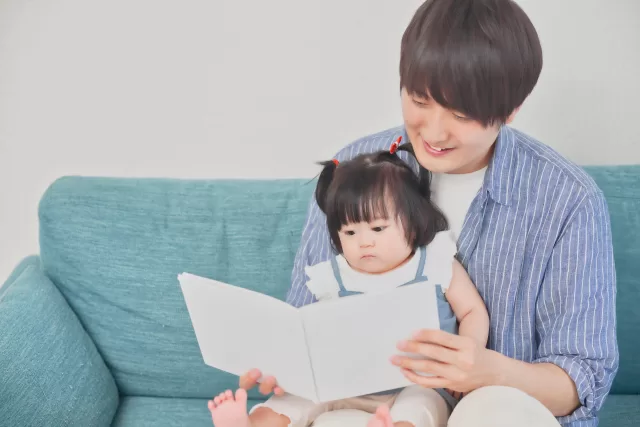 赤ちゃん絵本の読み聞かせをするパパ